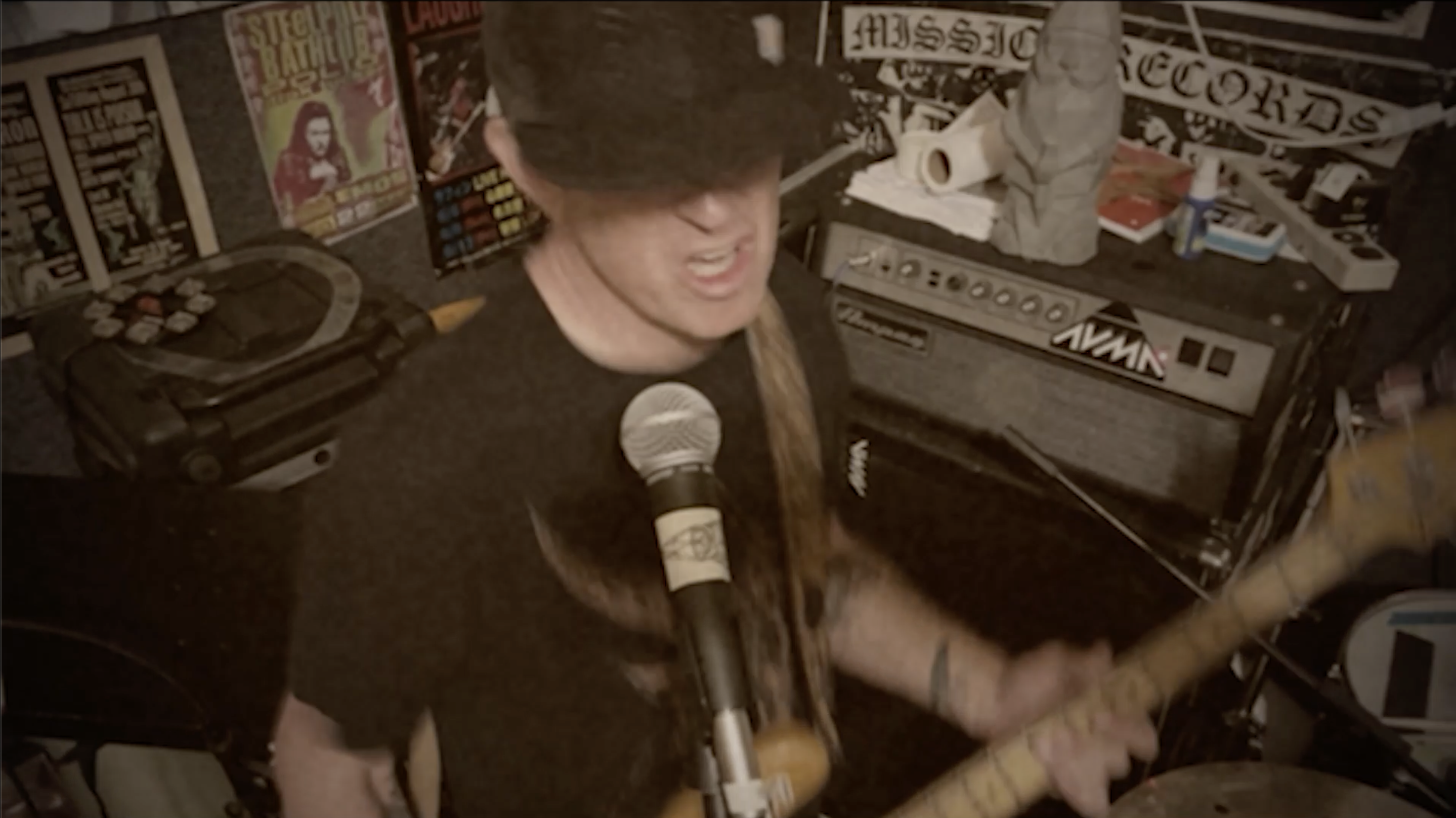 Confused Wizard promo video still image of Adam playing bass and singing